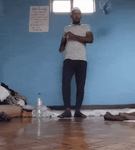 Man By Blue Wall With A Sign GIF