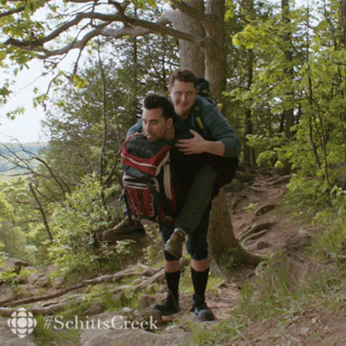 Man Carrying Another Man On His Back In Woods GIF