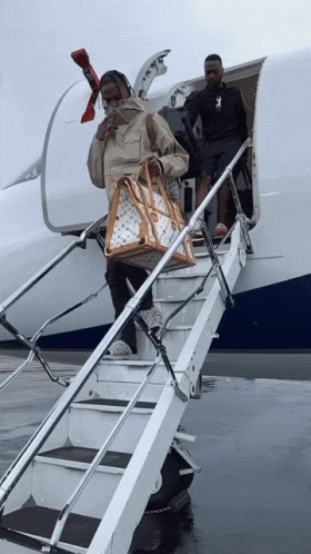 Man Carrying Louis Vuitton Bag Walking Down Stairs