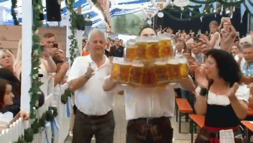 Man Carrying Stack Of Beer Mugs In Front Of Crowd GIF
