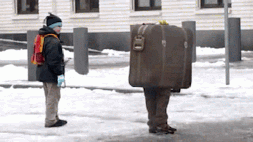 Man Carrying Suitcase on Back in Snow