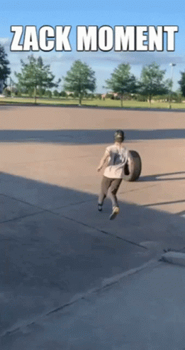 Man Carrying Tire in Parking Lot