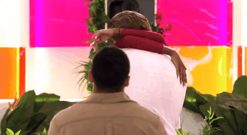 Man Carrying Woman on Back Pink Wall