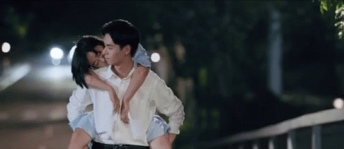 Man Carrying Woman On Shoulders Kissing GIF