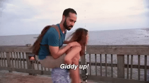 Man Carrying Woman on Shoulders