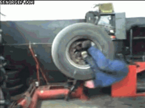 Man Changing Tire on Machine