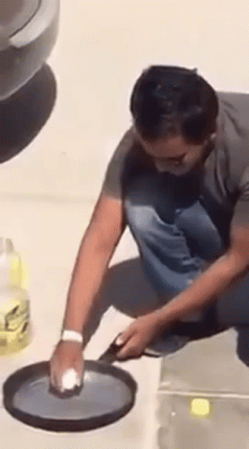Man Cleaning Pan with Sponge