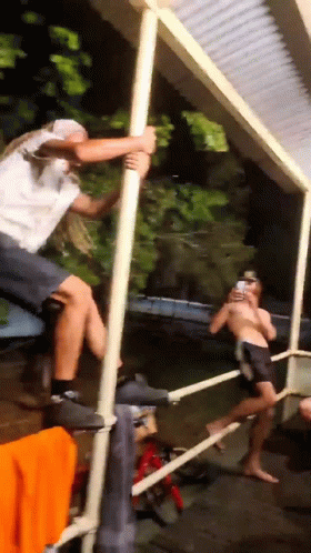 Man Climbing Pole To Take Photo GIF