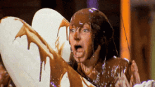 Man Covered in Chocolate Holding White Heart