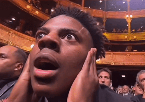 Man Covering Ears In Crowded Theater GIF