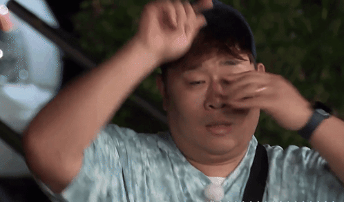 Man Covering Eyes With Hands Wearing Hat