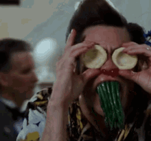 Man Covering Eyes With Sliced Potatoes Eating Green Beans