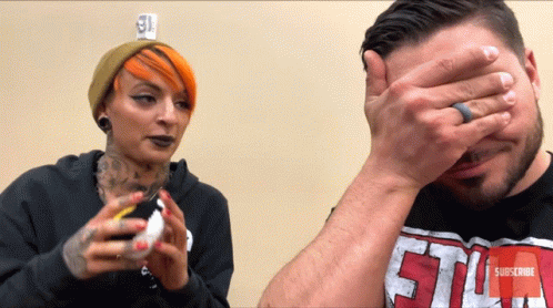 Man Covering Face Next To Red Haired Woman GIF