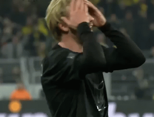 Man Covering Face on Soccer Field