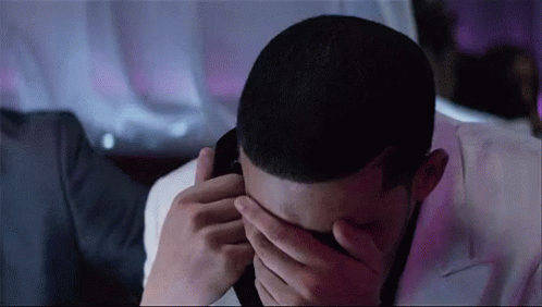 Man Covering Face Talking on Phone