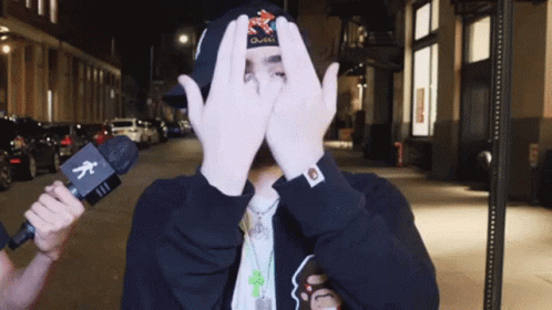 Man Covering Face With Hands Holding Microphone