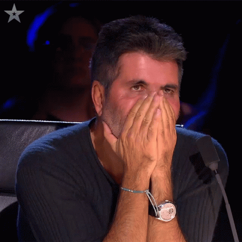 Man Covering Face With Hands in Front of Microphone