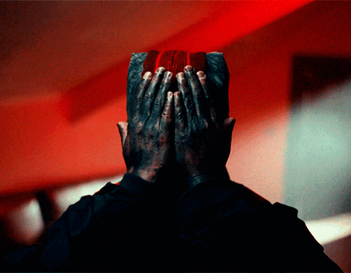 Man Covering Face With Hands Red Background