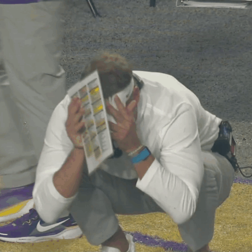 Man Covering Face With Paper and Nike Watch