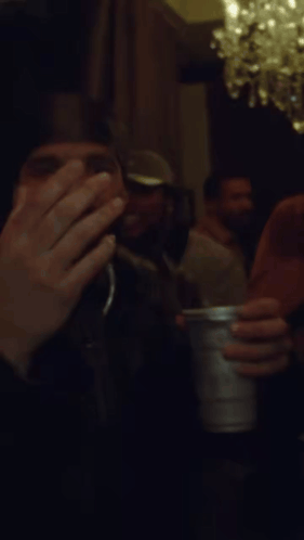 Man Covering Face with Silver Cup