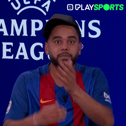 Man Covering Mouth in Front of UEFA Champions League Sign