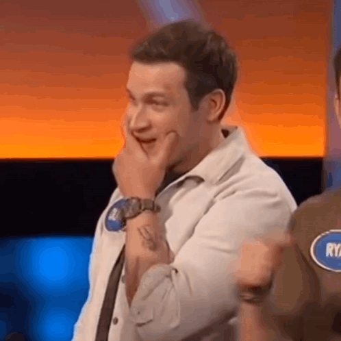 Man Covering Mouth Wearing Watch on TV Show
