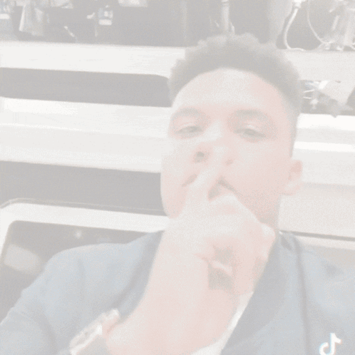 Man Covering Mouth With Finger TikTok Logo