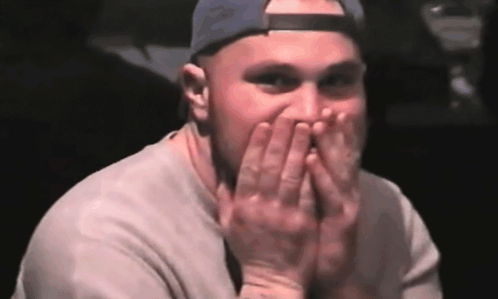Man Covering Mouth with Hands in Baseball Cap