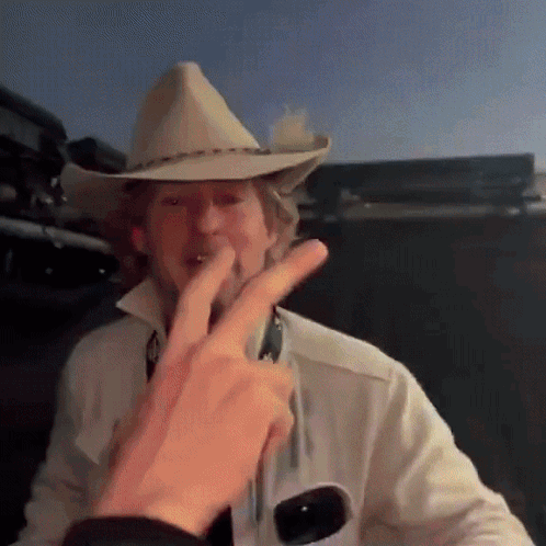 Man Cowboy Hat White Shirt Giving Peace Sign
