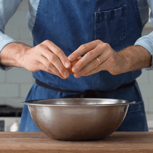Man Cracking Egg Into Metal Bowl