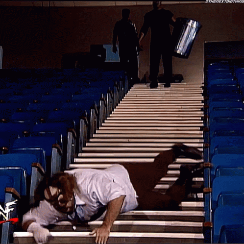 Man Crawling Stairs Watched by Man With Box