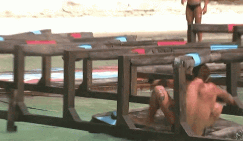 Man Crawling Through Wooden Fence Woman in Background