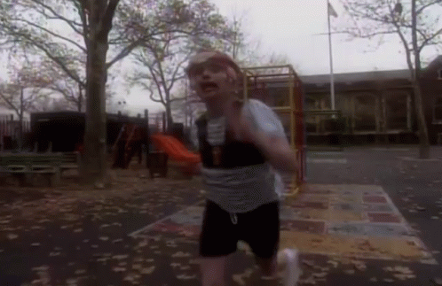 Man Crawling Under Yellow Ladder with Soccer Ball