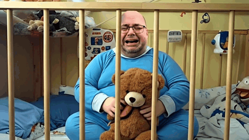 Man Crying While Holding Teddy Bear Behind Bars