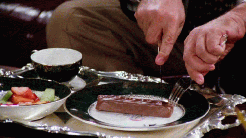 Man Cutting Chocolate With Knife and Fork