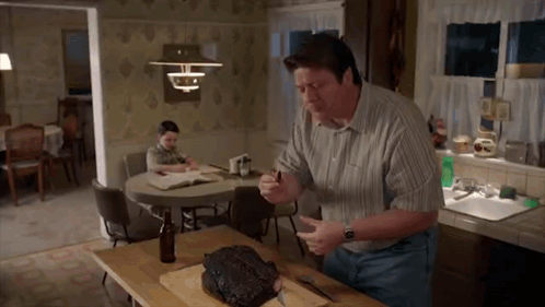 Man Cutting Meat on Board