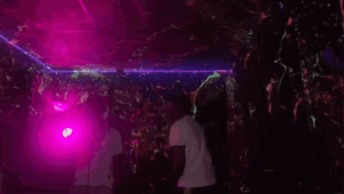 Man Dancing in Dark Room with Purple Lights