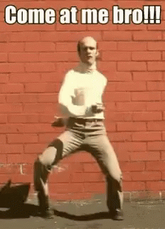 Man Dancing in Front of Red Brick Wall Saying Come at Me Bro