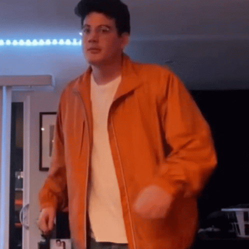 Man Dancing In Orange Jacket And White Shirt GIF