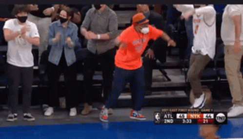 Man Dancing in Orange Shirt Before Crowd