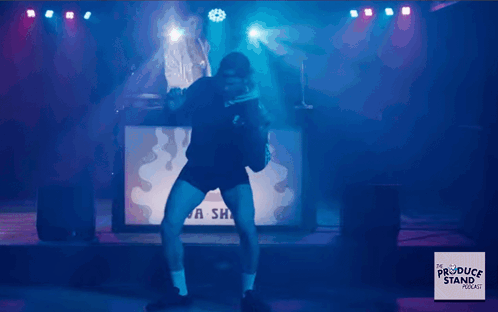 Man Dancing On Stage In Front Of A Sha Sign GIF