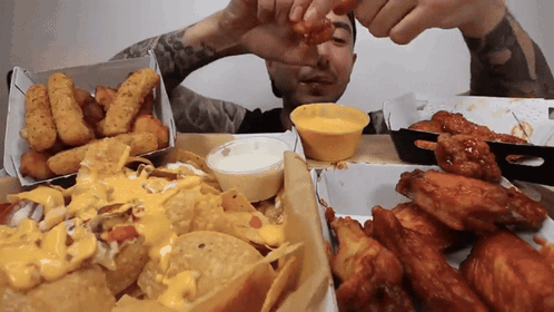 Man Dipping Chicken Wing In Yellow Sauce GIF