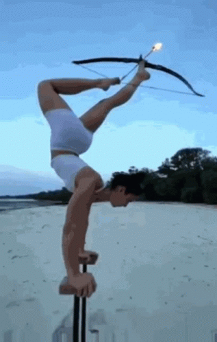 Man Doing Handstand With Bow And Arrow On Pole GIF