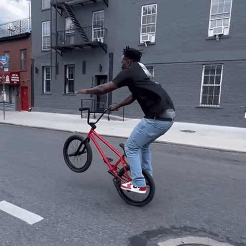 Man Doing Trick on Red Bicycle