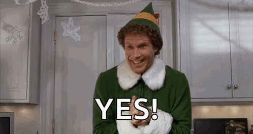 Man Dressed As Christmas Elf Smiling Saying Yes In Kitchen GIF