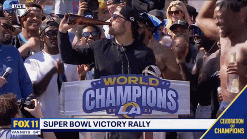 Man Drinking Beer in Front of World Champions Sign