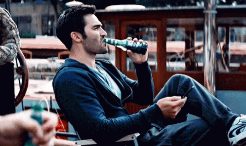 Man Drinking Bottle Holding Cell Phone