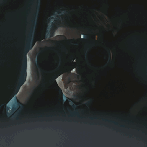 Man Driving Car in Dark Looking Out Window