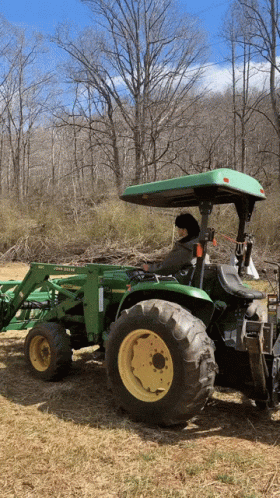 Man Driving Green John Deere Tractor in Field