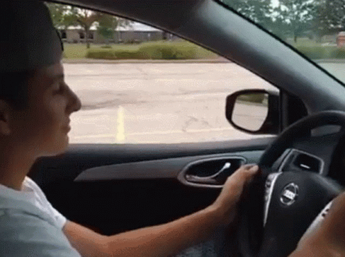 Man Driving Nissan Car and Looking Out Window
